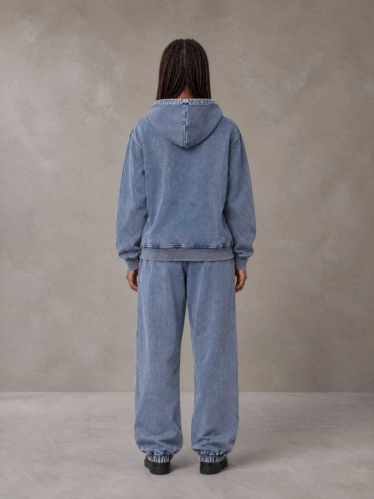 Model wearing the SM Denim Wash Zip Hoodie in Chambray, rear view.