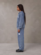 Model wearing the SM Denim Wash Zip Hoodie in Chambray, side profile.