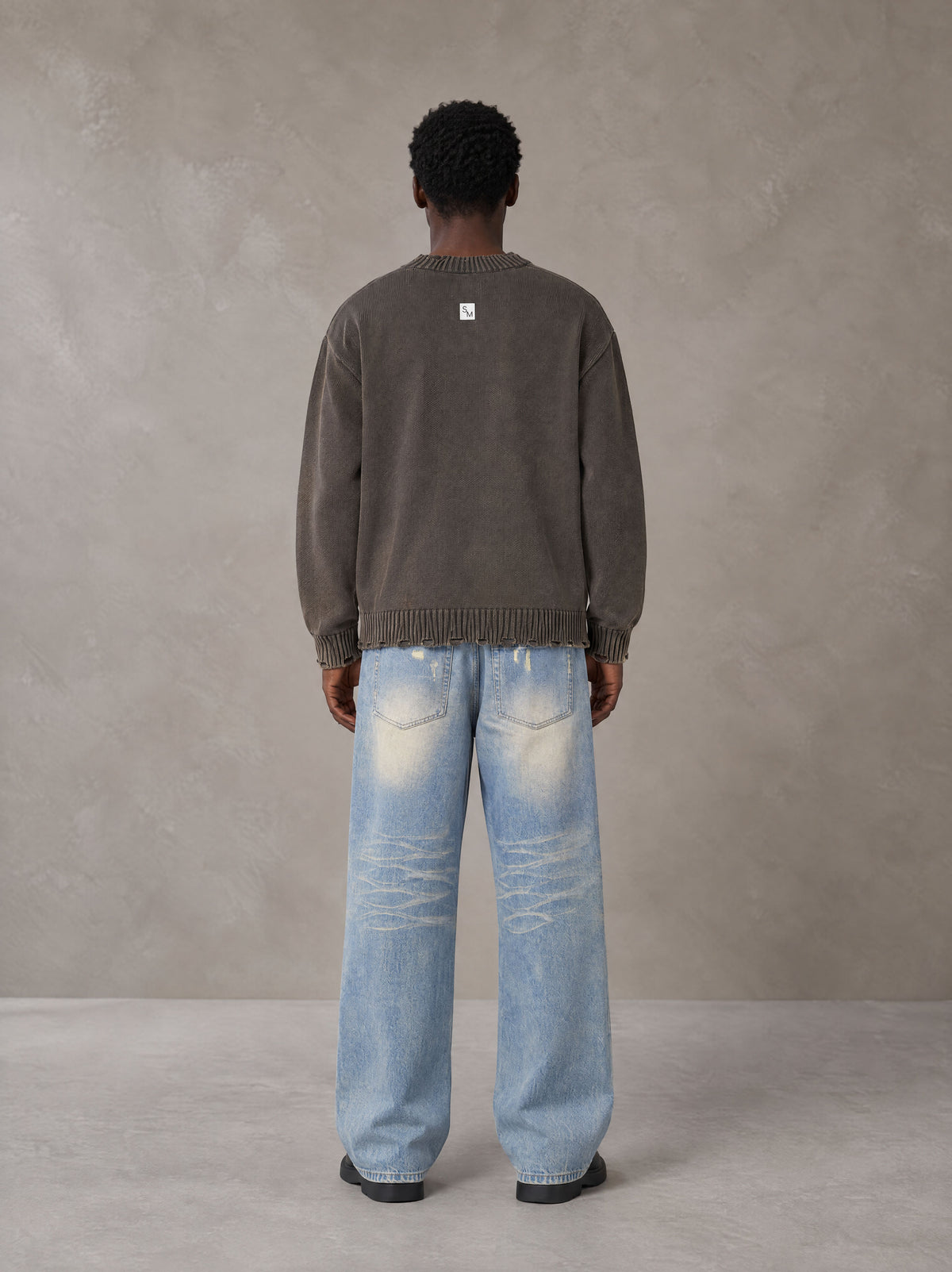 Model wearing the SM Heritage Fade Wide Leg Jeans in Cadet Grey, rear view.