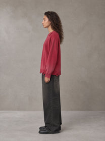 Model wearing the SM Sig. Washed Distress Knit Sweater in Deep Carmine, side profile.