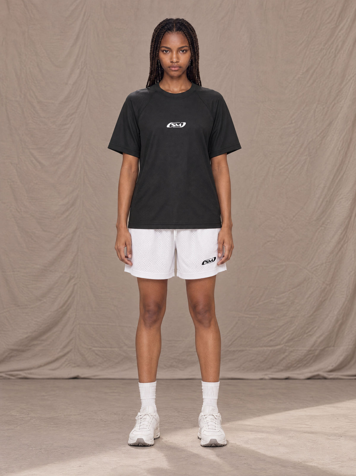 Model wearing the SM Motion Mesh Shorts in Lucent White, front view.