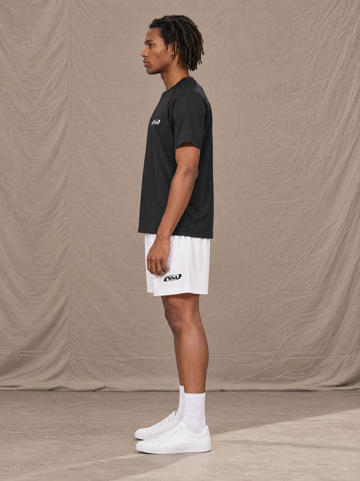 Model wearing the SM Motion Mesh Shorts in Lucent White, side profile.