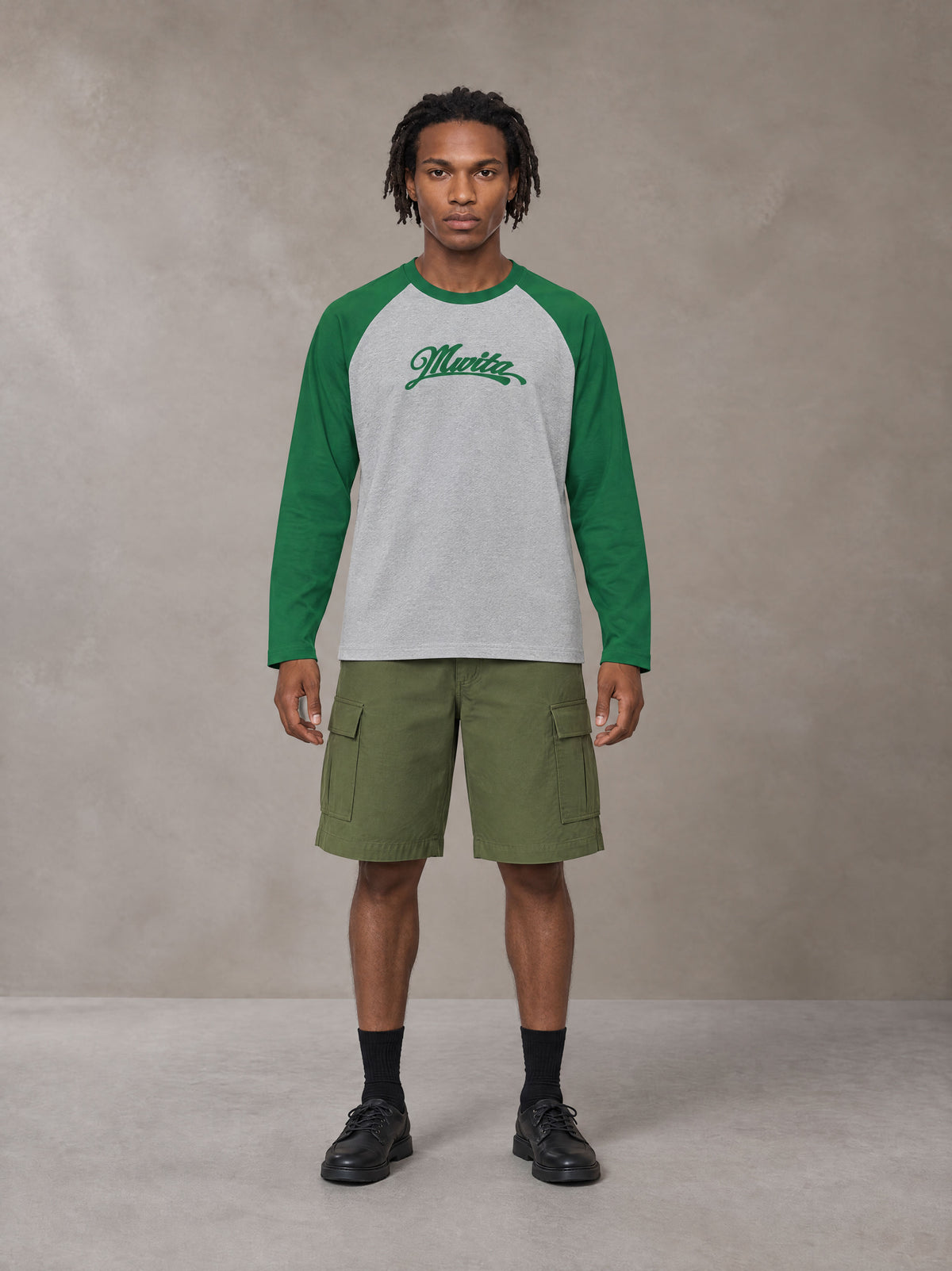Model wearing SM Retro Raglan Long-Sleeve T-shirt in Heather Grey, front view.