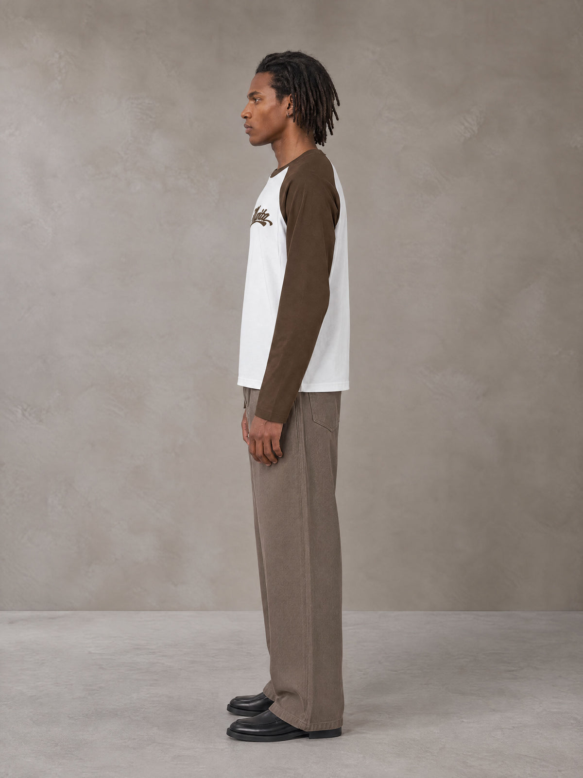 Model wearing SM Retro Raglan Long-Sleeve T-shirt in Lucent White, side profile.
