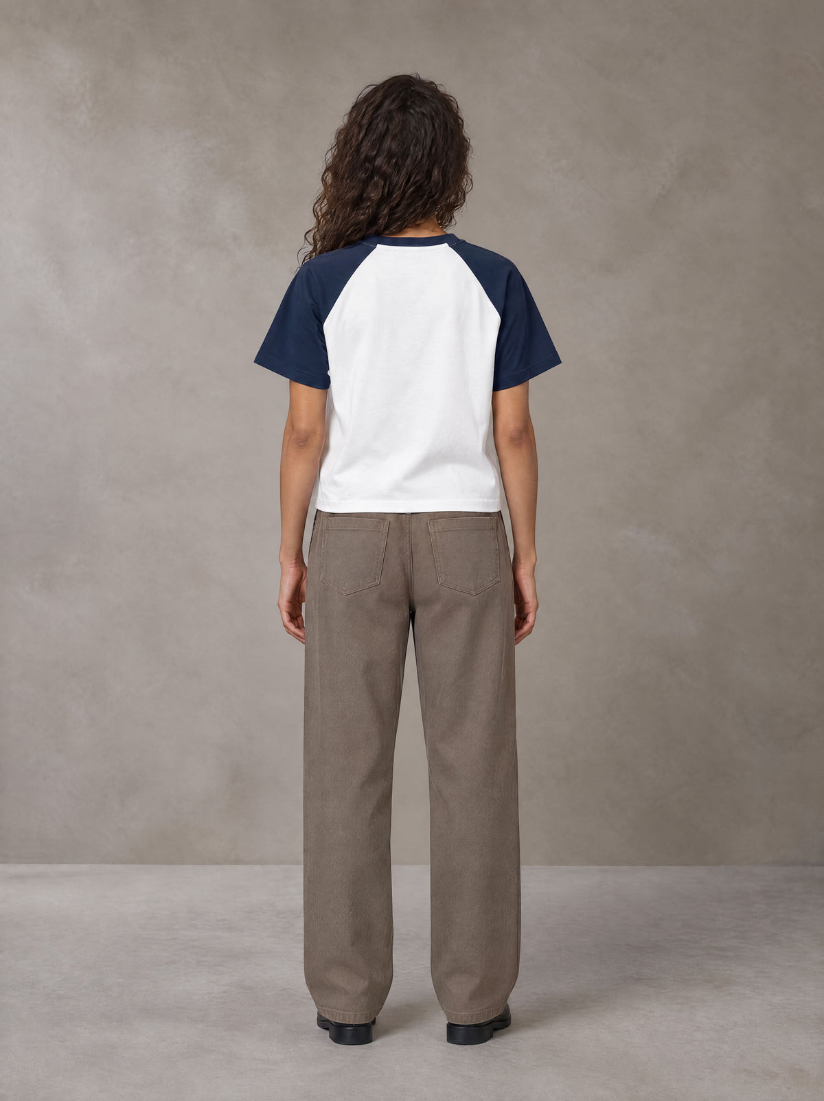 Model wearing SM Retro Raglan T-shirt in Oxford Navy, rear view.