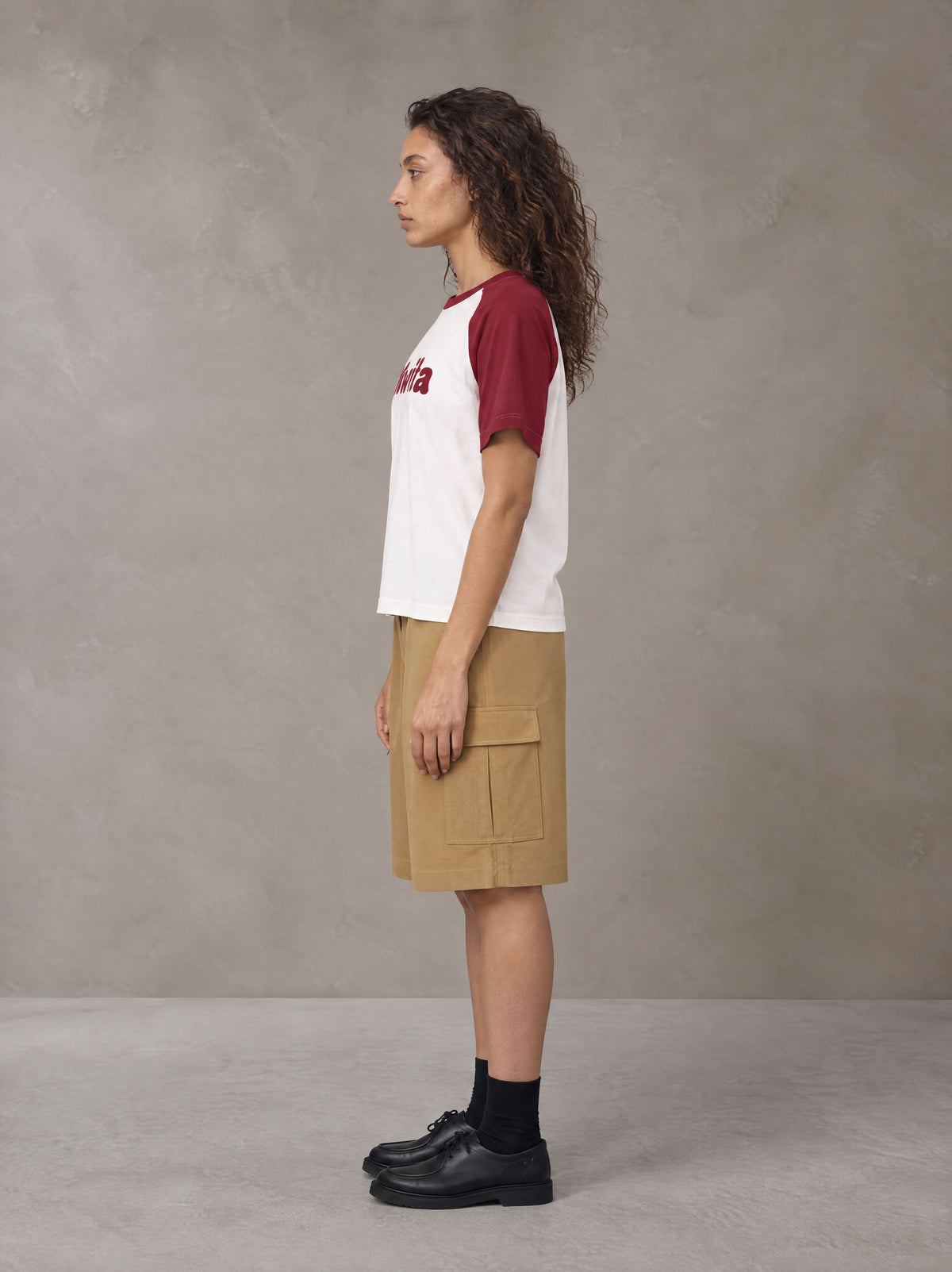 Model wearing SM Retro Raglan T-shirt in Burgundy, side profile.