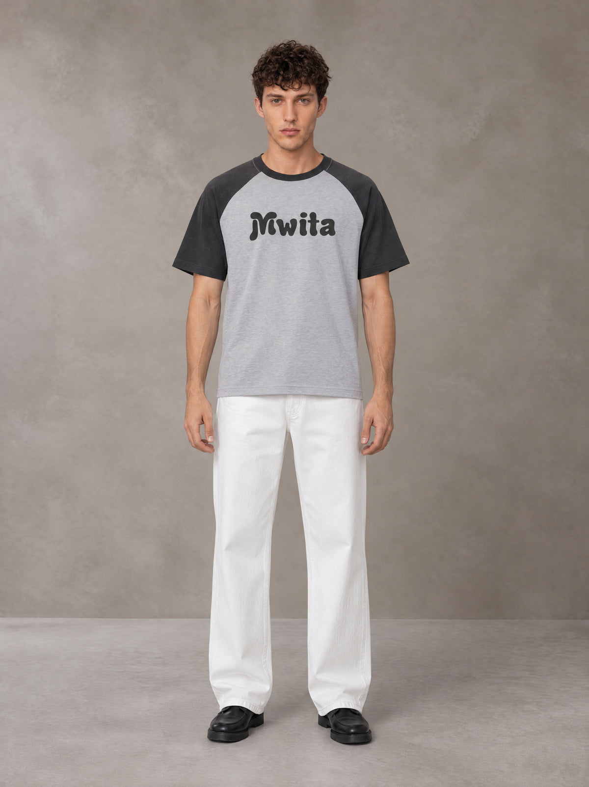 Model wearing SM Retro Raglan T-shirt in Deep Charcoal, front view.