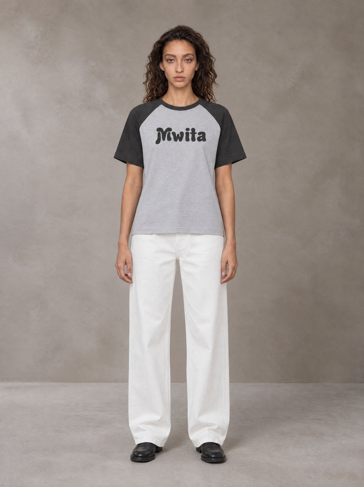 Model wearing SM Retro Raglan T-shirt in Deep Charcoal, front view.