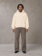 Model wearing SM Sig. Boxy Hoodie in Apricot Tint, front view.