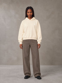 Model wearing SM Sig. Boxy Hoodie in Apricot Tint, front view.