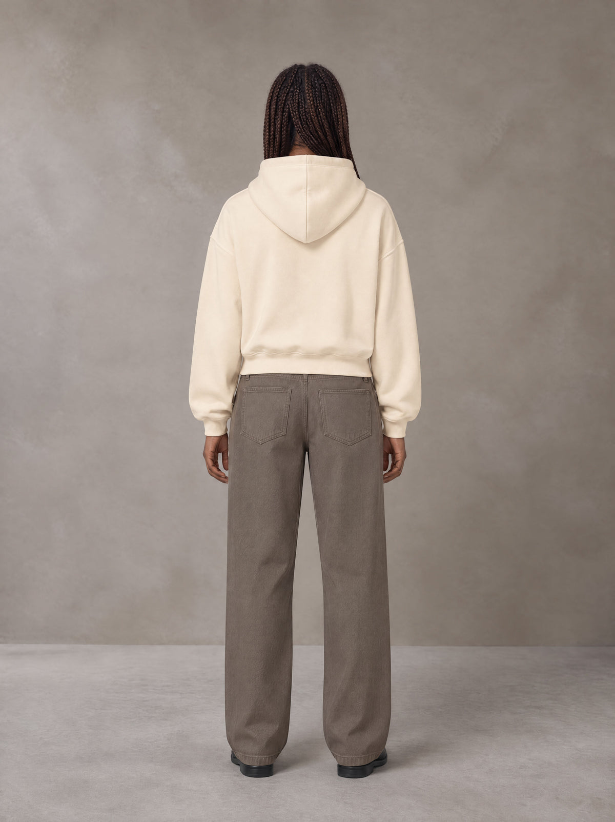 Model wearing SM Sig. Boxy Hoodie in Apricot Tint, rear view.