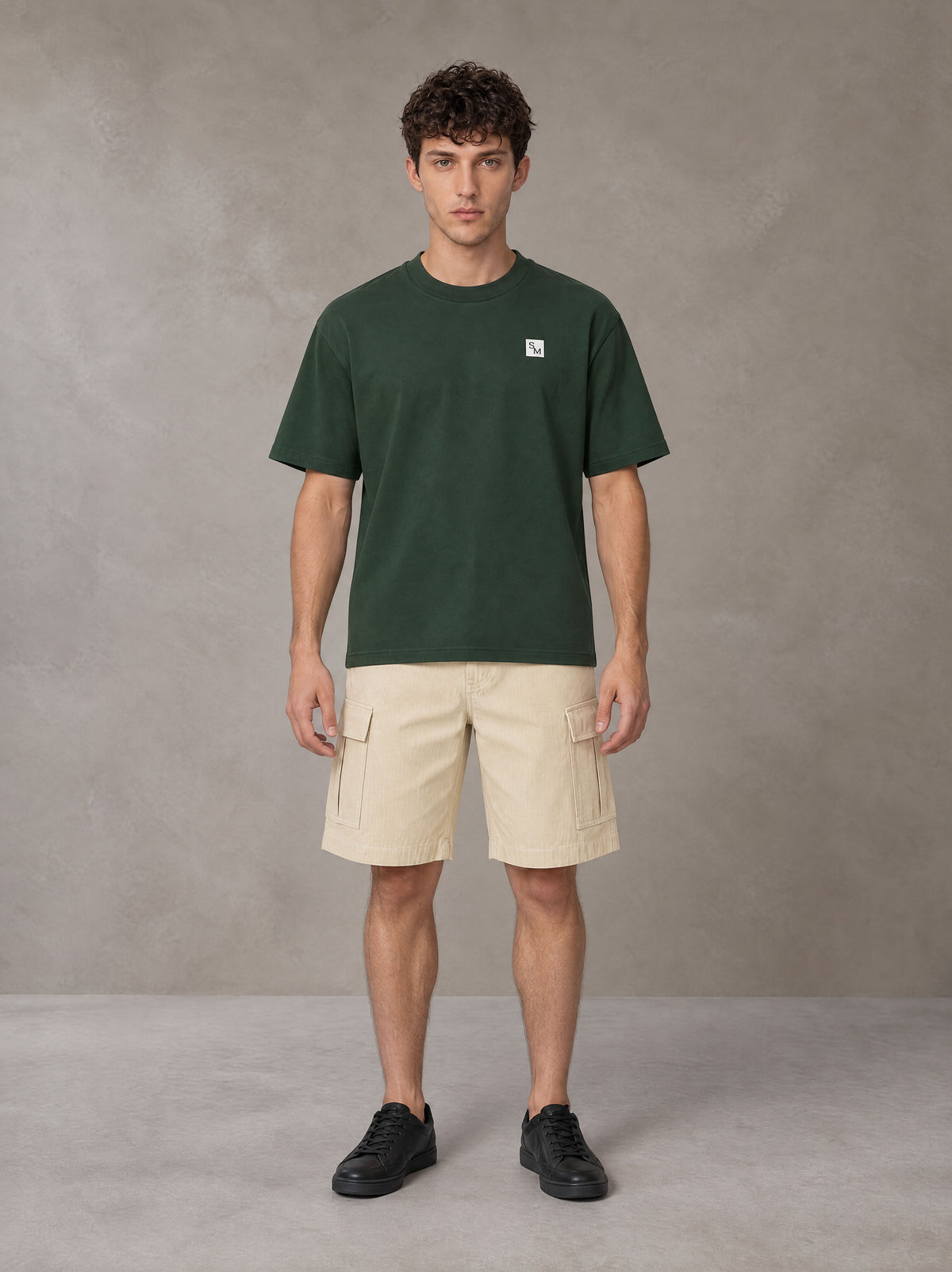 Model wearing SM Sig. Earth T-shirt in Alpine Green, front view.