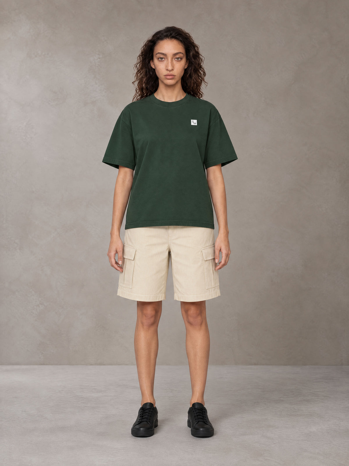 Model wearing SM Sig. Earth T-shirt in Alpine Green, front view.