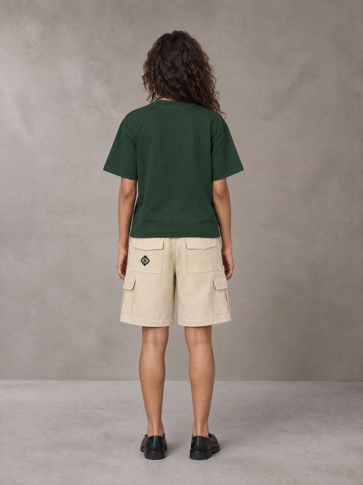 Model wearing SM Sig. Earth T-shirt in Alpine Green, rear view.