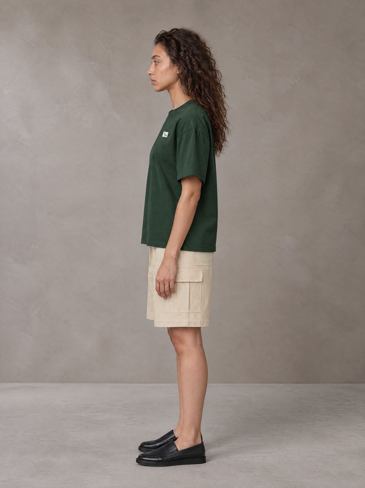 Model wearing SM Sig. Earth T-shirt in Alpine Green, side profile.