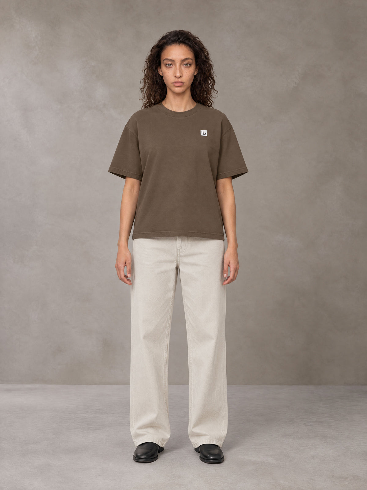 Model wearing SM Sig. Earth T-shirt in Brown, front view.