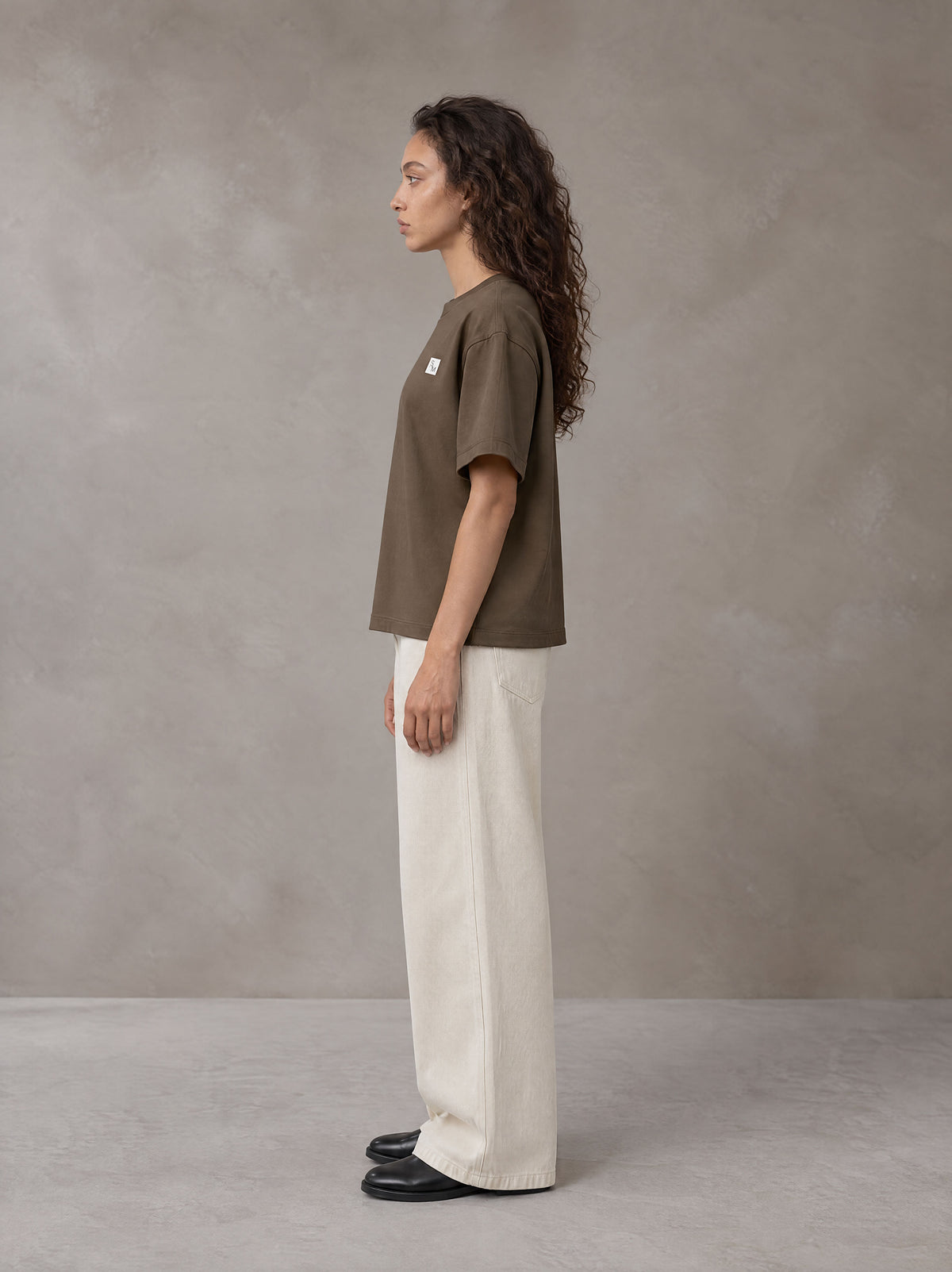 Model wearing SM Sig. Earth T-shirt in Brown, side profile.
