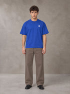 Model wearing SM Sig. Earth T-shirt in Classic Blue, front view.