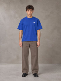 Model wearing SM Sig. Earth T-shirt in Classic Blue, front view.