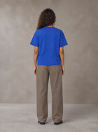 Model wearing SM Sig. Earth T-shirt in Classic Blue, rear view.