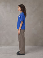 Model wearing SM Sig. Earth T-shirt in Classic Blue, side profile.