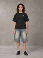 Model wearing SM Sig. Earth T-shirt in Midnight Black, front view.