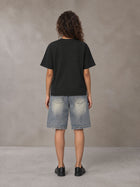 Model wearing SM Sig. Earth T-shirt in Midnight Black, rear view.