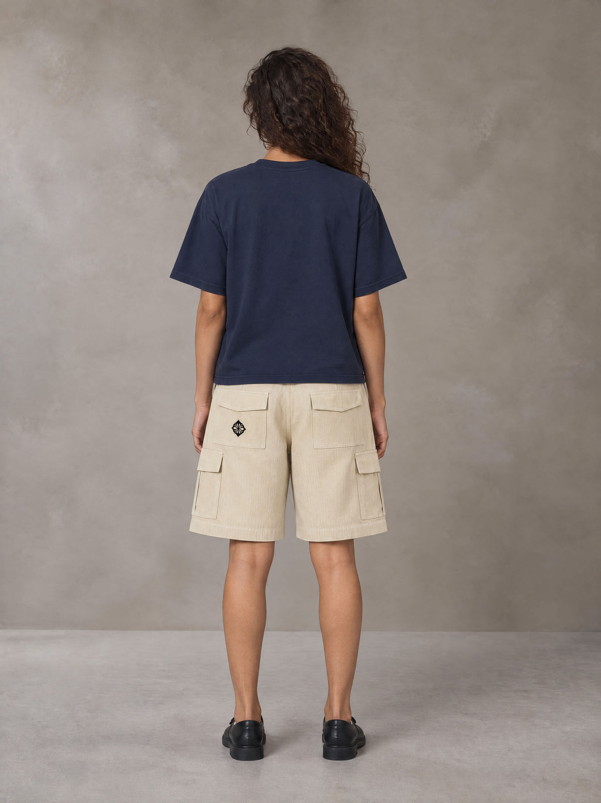 Model wearing SM Sig. Earth T-shirt in Oxford Navy, rear view.