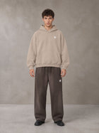 Model wearing SM Sig. Fleece Hoodie in Apricot Grey, front view.