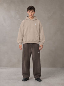 Model wearing SM Sig. Fleece Hoodie in Apricot Grey, front view.