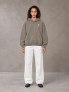 Model wearing SM Sig. Fleece Hoodie in Coffee Grey, front view.
