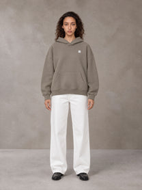 Model wearing SM Sig. Fleece Hoodie in Coffee Grey, front view.