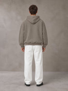 Model wearing SM Sig. Fleece Hoodie in Coffee Grey, rear view.