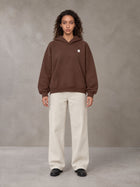 Model wearing SM Sig. Fleece Hoodie in Deep Coffee, front view.