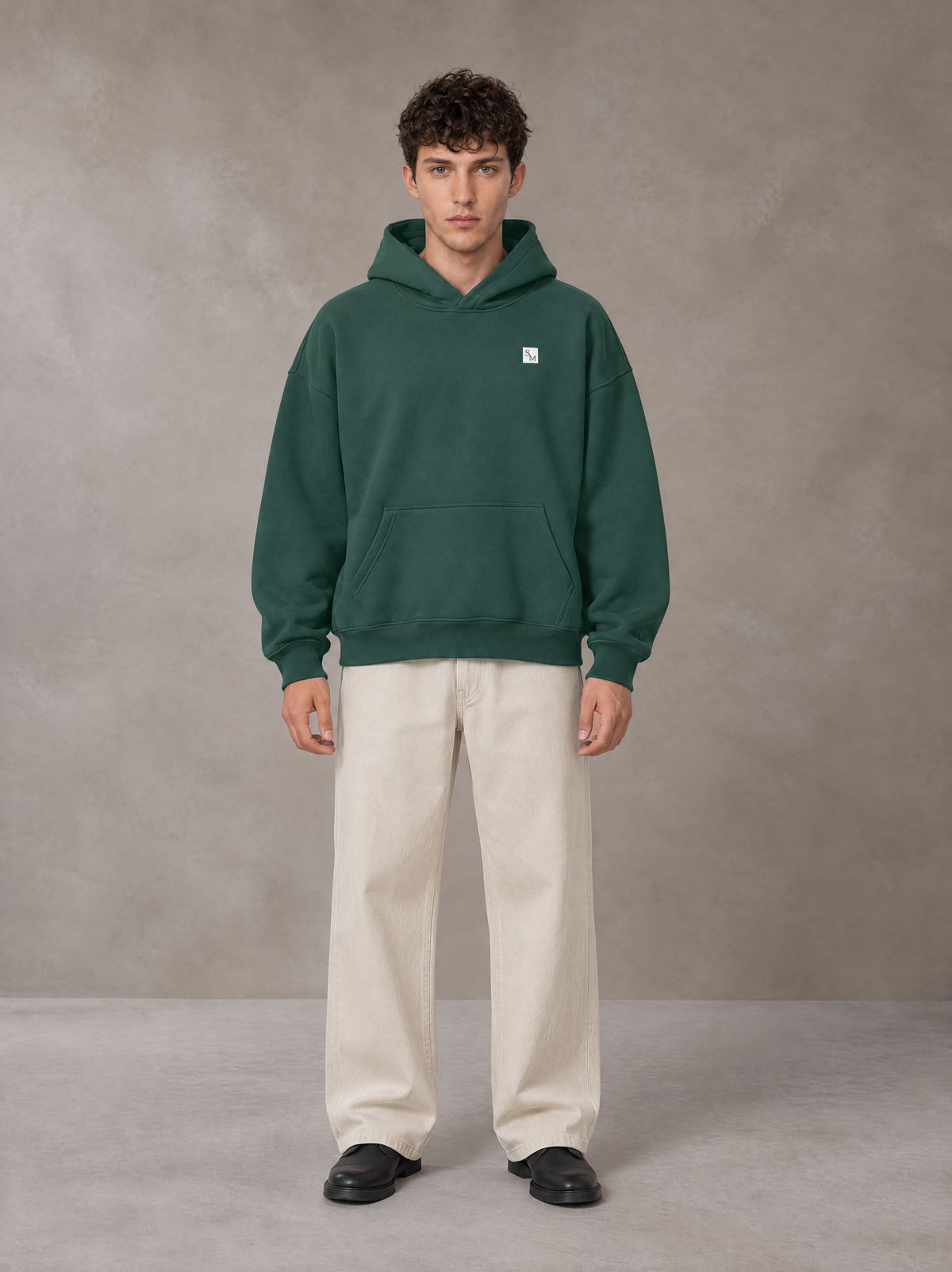 Model wearing SM Sig. Fleece Hoodie in Eden Green, front view.