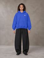 Model wearing SM Sig. Fleece Hoodie in Klein Blue, front view.