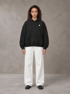 Model wearing SM Sig. Fleece Hoodie in Midnight Black, front view.