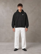 Model wearing SM Sig. Fleece Hoodie in Midnight Black, front view.