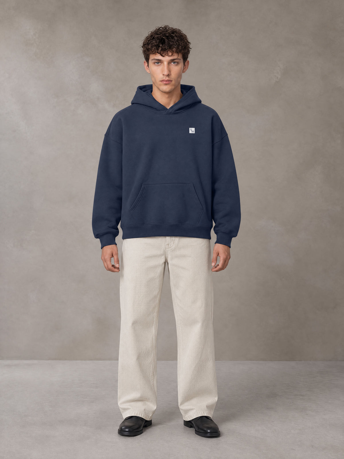 Model wearing SM Sig. Fleece Hoodie in Oxford Navy, front view.