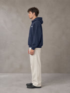 Model wearing SM Sig. Fleece Hoodie in Oxford Navy, side profile.