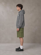 Model wearing SM Sig. Fleece Hoodie in Pure Grey, side profile.