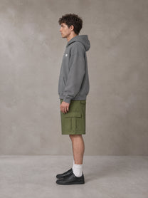 Model wearing SM Sig. Fleece Hoodie in Pure Grey, side profile.