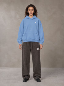 Model wearing SM Sig. Fleece Hoodie in Soft Blue, front view.