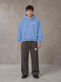 Model wearing SM Sig. Fleece Hoodie in Soft Blue, front view.