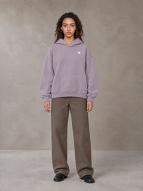 Model wearing SM Sig. Fleece Hoodie in Soft Lavender, front view.