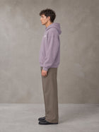 Model wearing SM Sig. Fleece Hoodie in Soft Lavender, side profile.