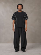 Model wearing SM Sig. Framework T-shirt in Midnight Black, front view.