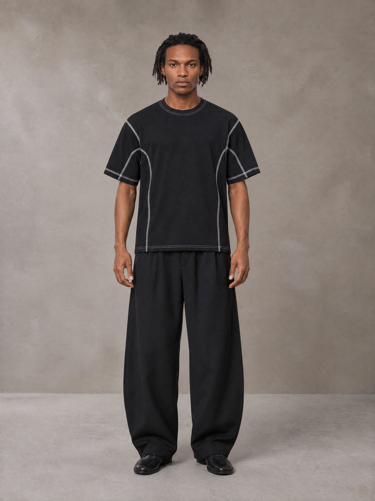 Model wearing SM Sig. Framework T-shirt in Midnight Black, front view.