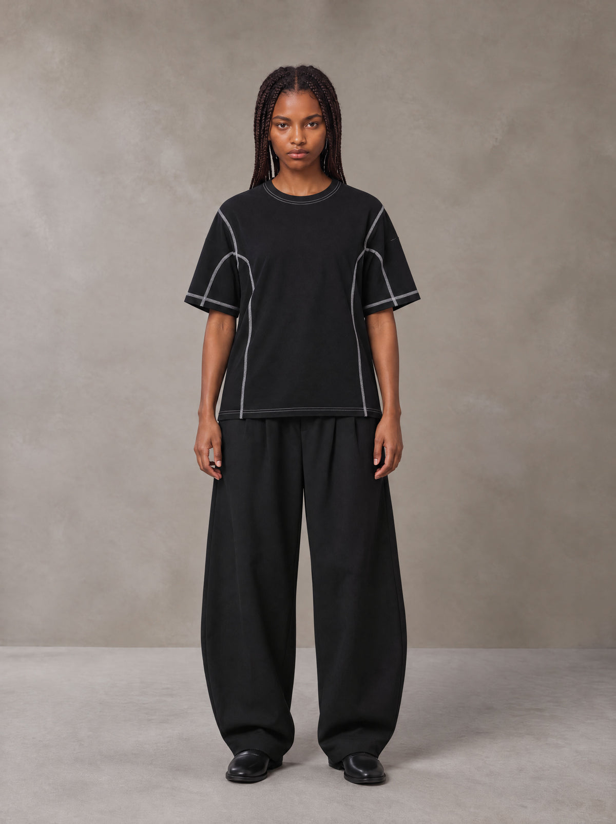 Model wearing SM Sig. Framework T-shirt in Midnight Black, front view.