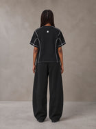Model wearing SM Sig. Framework T-shirt in Midnight Black, rear view.